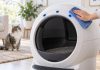 Hand cleaning the sensor area on a Litter-Robot 4